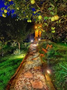 a garden at night with a pathway with lights at Sunrise Inn & Spa in Pessinetto