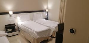 a hotel room with two beds and a phone at Hotel Boccascena in Genoa