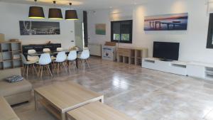 Una sala de estar con una mesa y un televisor. en Villa Franz House Casa Principal, en Canyelles