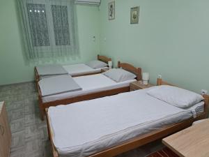 - un groupe de trois lits dans une chambre dans l'établissement MIMA apartmani, à Bečej