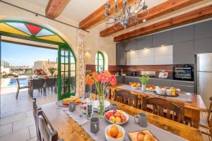 a kitchen and dining room with a table with food at Ta Kalang Holiday Home in Kerċem