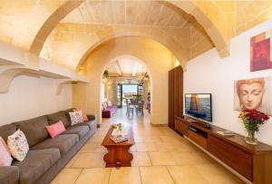 a living room with a couch and a tv at Ta Kalang Holiday Home in Kerċem