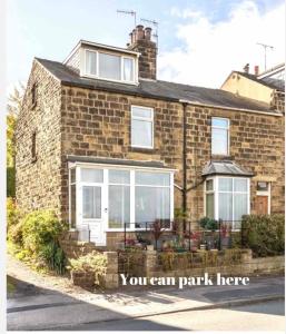a brick house with white doors and windows at Wharfe View Cottage Ilkley in Ilkley