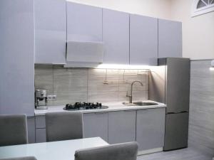 Luxury Centre Located Apartment في كييف: مطبخ مع دواليب بيضاء ومغسلة