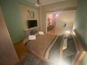 a small bedroom with a bed and a television at Balmoral Central Suite in Larisa