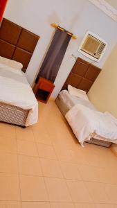 een kamer met 2 bedden en airconditioning bij شاليهات الدرب ليله دورين in Qarār