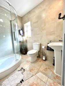 a bathroom with a toilet and a shower and a sink at Wharfe View Cottage Ilkley in Ilkley