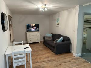 een woonkamer met een bank en een tafel bij Fantastic large 1 bed Loft Flat close to Heathrow - 77VFR5 in Cranford
