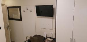 a living room with a tv on a white wall at Hotel Boccascena in Genoa