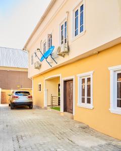 a yellow building with a blue airplane on the side of it at Mainstream Shortlet Apartments in Gbogije