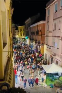 Une foule de gens marchant dans une rue la nuit dans l'établissement ART HOUSE, à Nuoro