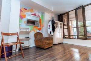 a living room with a chair and a refrigerator at Barcelona & You Hostel Sagrada Familia in Barcelona