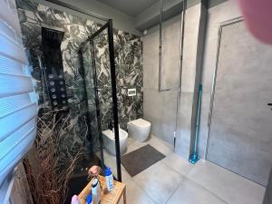 La salle de bains est pourvue d'une douche et de toilettes. dans l'établissement ART HOUSE, à Nuoro