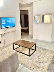 salon ze stolikiem kawowym i telewizorem w obiekcie Cozy 2 bedroom, master en-suite Apartment in Bamburi with secure environment WIFI Netflix and 10min drive to the beach w mieście Mombasa