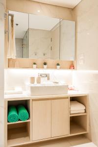 La salle de bains est pourvue d'un lavabo et d'un miroir. dans l'établissement Cassia Residences 2 Bedroom with terrace Sea View by NLA, à Bang Tao Beach