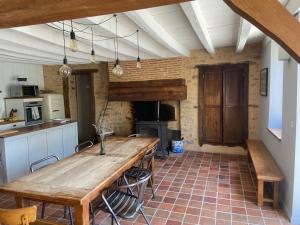 a kitchen with a wooden table in a room at Maison de campagne authentique et chaleureuse in Fougerolles