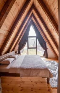 a bed in a room with a large window at Lux Villas Zabljak in Žabljak
