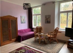 a living room with a purple couch and a table at Gutshaus Zarnewanz in Zarnewanz