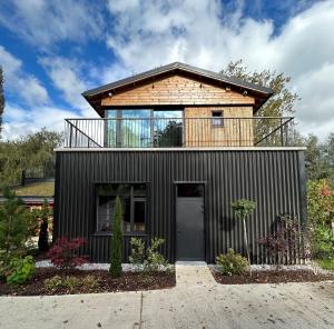 una casa con balcón en la parte superior en Cabanes avec jacuzzi les pieds dans la vignes, 