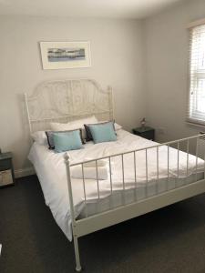 een slaapkamer met een wit bed en 2 blauwe kussens bij Fantastic large 1 bed Loft Flat close to Heathrow - 77VFR5 in Cranford