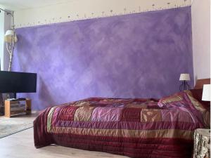a bedroom with a purple wall and a bed at Gutshaus Zarnewanz in Zarnewanz