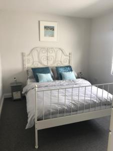 een slaapkamer met een wit bed met blauwe kussens bij Fantastic large 1 bed Loft Flat close to Heathrow - 77VFR5 in Cranford