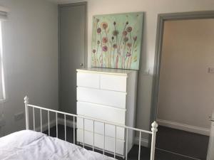 een slaapkamer met een bed en een schilderij aan de muur bij Fantastic large 1 bed Loft Flat close to Heathrow - 77VFR5 in Cranford