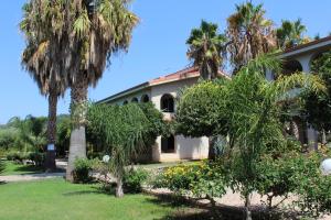 a house with palm trees in the yard at Delta Club Residence in Capo Vaticano