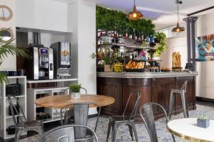 ein Restaurant mit Tischen und Stühlen und eine Bar in der Unterkunft Lennon by Avalon Hotel Paris Gare du Nord in Paris