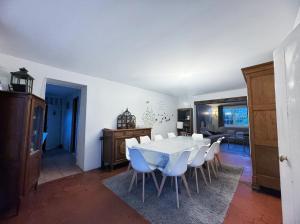 a dining room with a white table and white chairs at Chez Madame Titus in Ormoy-Villers