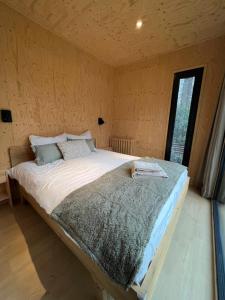 a large bed in a room with a window at Taiga tiny house in Nunspeet