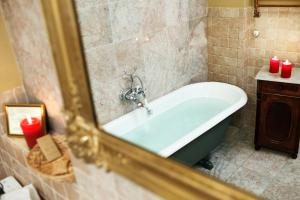a bath tub in a bathroom with a mirror at Apartamenty Kamienica Muzyków Old Town Lublin in Lublin