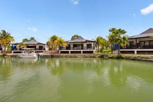 um corpo de água com casas e um barco em Waterlands Villa Sol Bonaire em Kralendijk