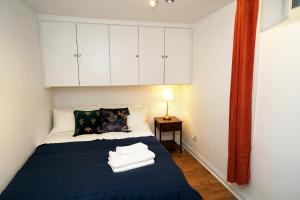 1 dormitorio con 1 cama azul y armarios blancos en Cozy Retreat By Aresti Hotels, en Londres