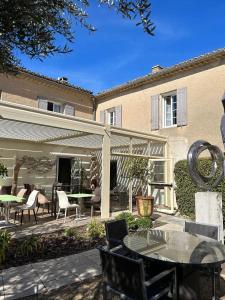 un patio avec une table et des chaises et un bâtiment dans l'établissement Mas des Carassins, à Saint-Rémy-de-Provence