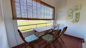 a table and chairs in a room with a window at Zahara pueblo con parking y piscina in Zahara de los Atunes