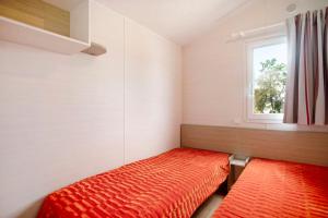 a small room with a bed and a window at Bungalow T2 i i i - 15 Min Nazaré in Pataias