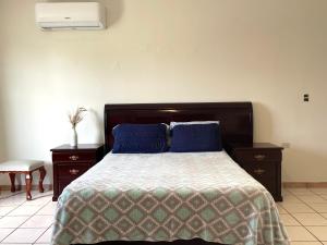 a bedroom with a bed with blue pillows at Casa Baraka, Casa Vacacional en Mazatlán cerca de Malecón, Centro Histórico y Playa in Mazatlán