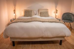 O'Kub du Ried في Rossfeld: غرفة نوم بسرير مع وسادتين وكرسي