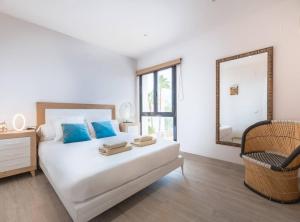 Un dormitorio con una cama con un espejo y una silla. en Villa Sa Marinada | 100m de Mar, en Sant Josep de sa Talaia