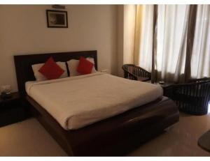 a bedroom with a bed with red pillows at Hotel lords,Dehradun in Dehradun