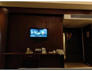uma sala de estar com televisão na parede em Hotel lords,Dehradun em Dehradun