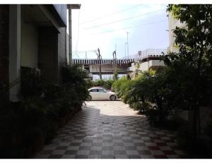 a white car driving down a street with a bridge at Hotel lords,Dehradun in Dehradun