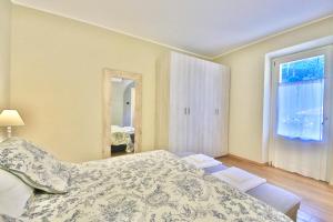 1 dormitorio con cama y ventana grande en Renzo Bellagio by KlabHouse, en Bellagio