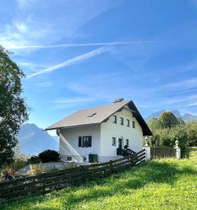 Landl的住宿－Ferienhaus sHäuserl，一座白色的房子,在田野上有一个金属屋顶