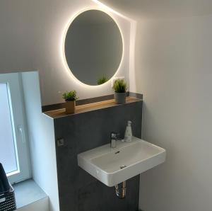 a bathroom with a white sink and a mirror at Wohnung Utkiek - Alte Schule in Glowe