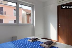Certosa District Apartment في ميلانو: غرفة نوم عليها سرير وفوط