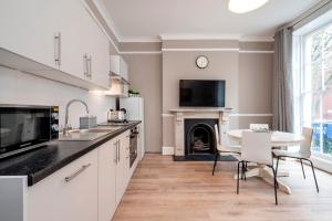 a kitchen with a table and a fire place at Hyde Park Modern Apartments in London