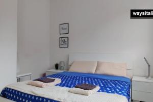 Certosa District Apartment في ميلانو: غرفة نوم عليها سرير وفوط
