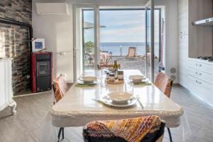 uma sala de jantar com uma mesa e vista para o oceano em casa Ciapin em Cipressa